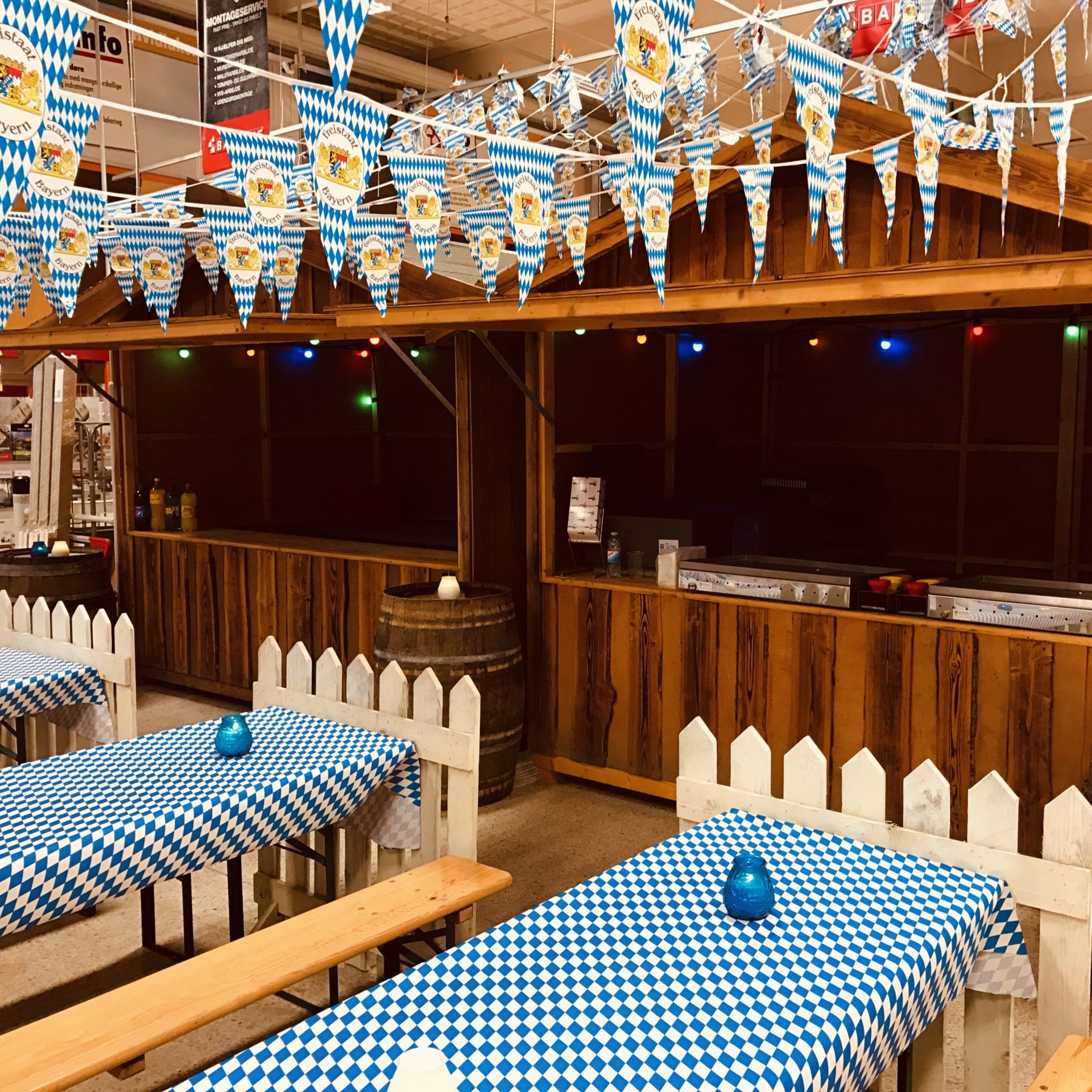 Eight shirts arranged on table in black, olive, grey, blue, white, red, mustard, and green.
