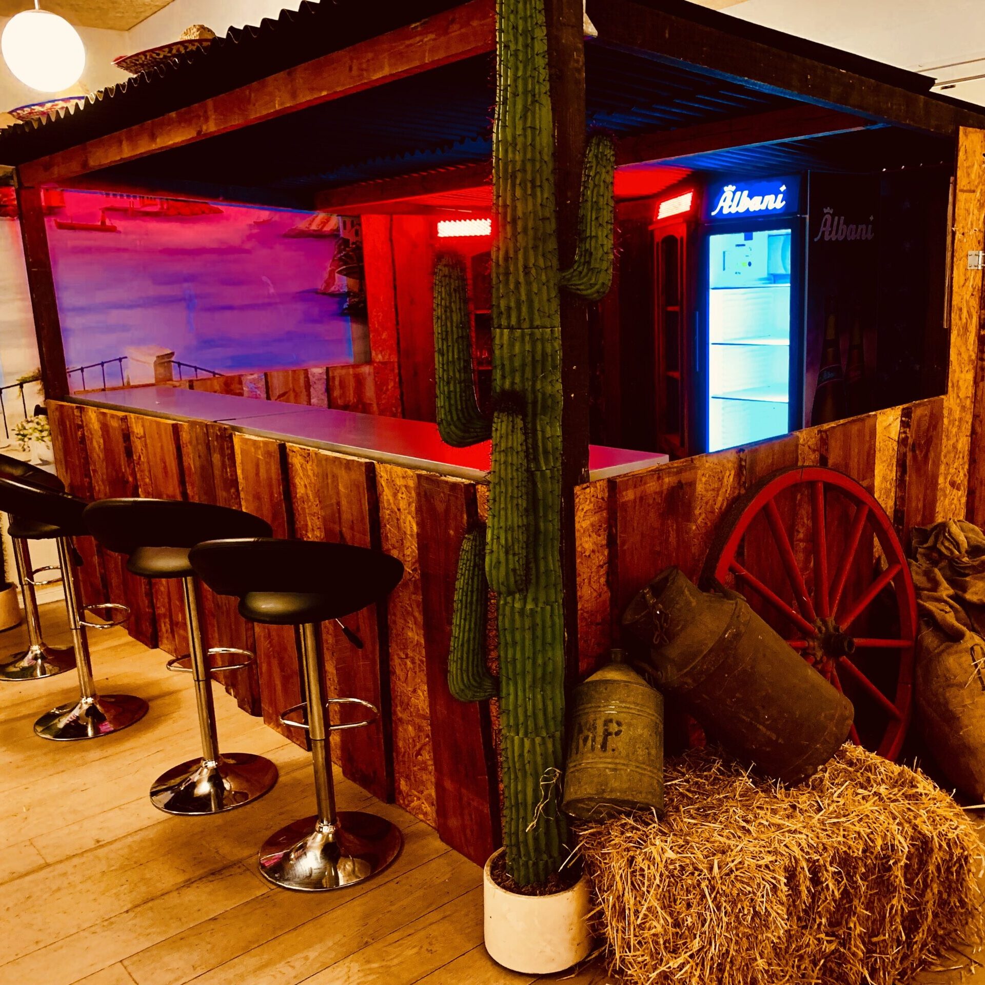 Eight shirts arranged on table in black, olive, grey, blue, white, red, mustard, and green.