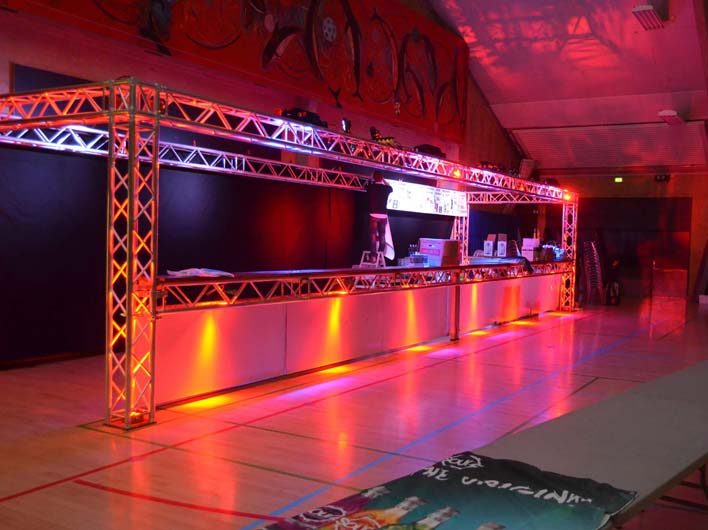 Eight shirts arranged on table in black, olive, grey, blue, white, red, mustard, and green.