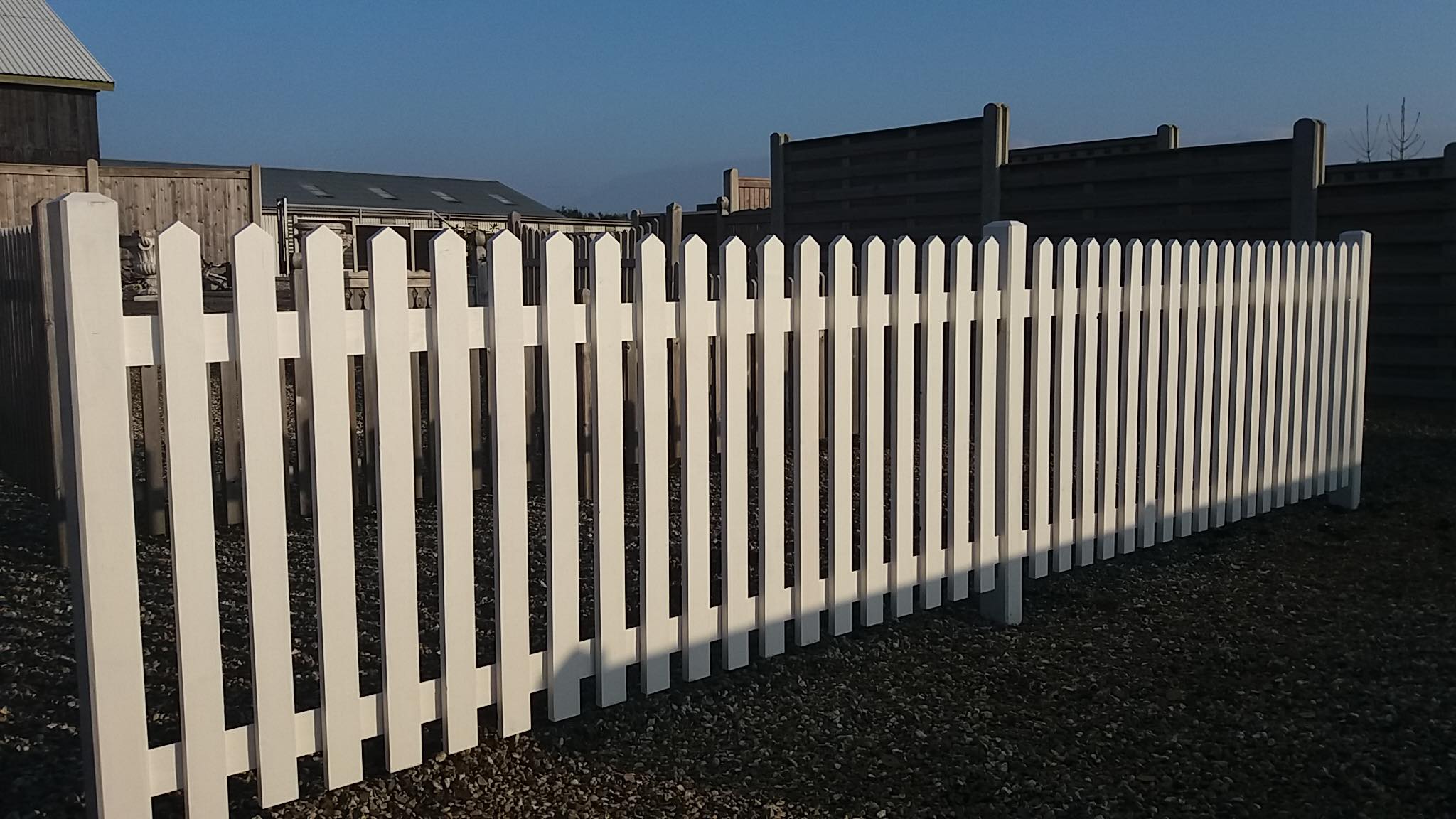 Eight shirts arranged on table in black, olive, grey, blue, white, red, mustard, and green.