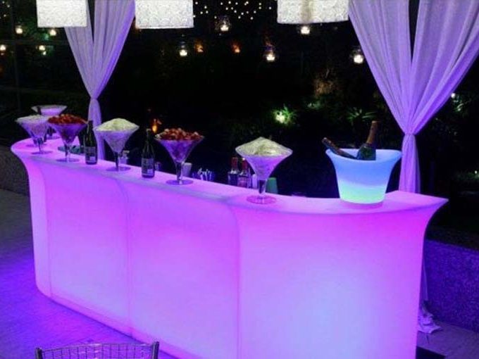 Eight shirts arranged on table in black, olive, grey, blue, white, red, mustard, and green.